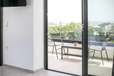 a glass door with a table and chairs on a balcony at Habitat Inn Faliraki View Villa Rhodes in Kalithies