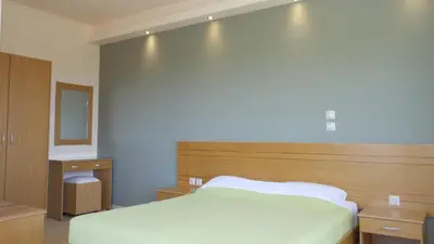 a bedroom with a white bed and a mirror at Villa Olive Grove in Afantou