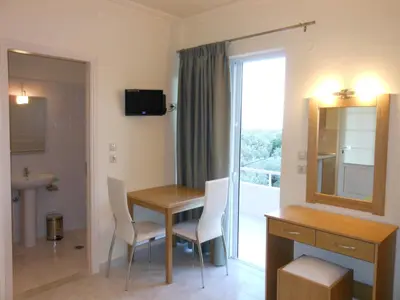 a room with a table and chairs and a mirror at Villa Olive Grove in Afantou