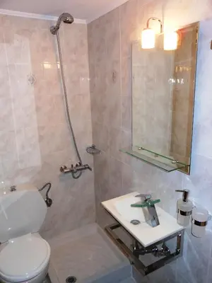 a bathroom with a toilet and a sink and a mirror at Villa Olive Grove in Afantou