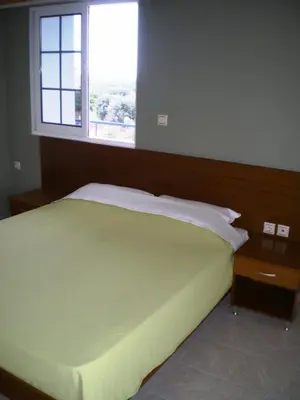 a bedroom with a large bed with a window at Villa Olive Grove in Afantou