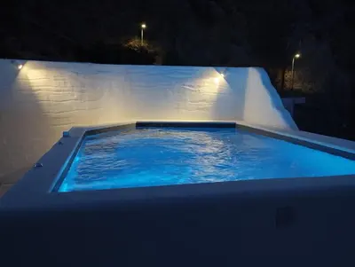 a large swimming pool at night with lights on it at Filia Bungalow in Archangelos