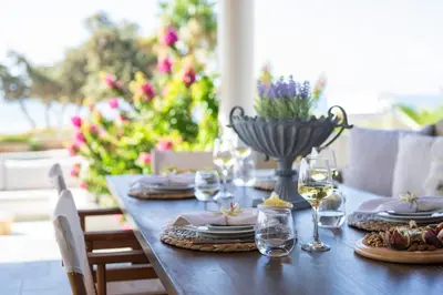 a wooden table with plates and glasses of wine at Villa Del Nonno in Lardos