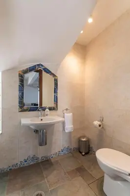 a bathroom with a sink and a toilet and a mirror at Villa Del Nonno in Lardos