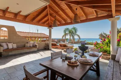 an outdoor patio with a table and chairs and the ocean at Villa Del Nonno in Lardos