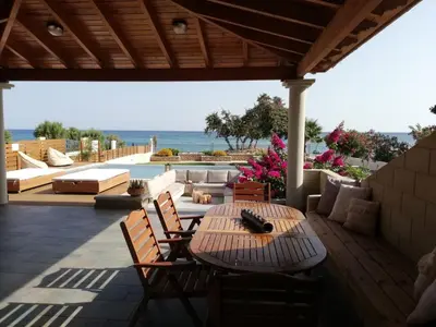 a patio with a table and chairs and a pool at Villa Del Nonno in Lardos