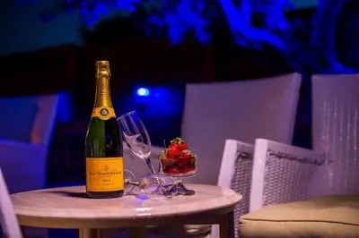 a bottle of wine sitting on a table with a wine glass at Villa Linda Tsambika Afandou in Afantou