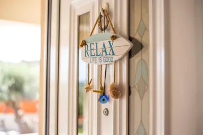 a sign on a door that reads relax life is slow at Villa Linda Tsambika Afandou in Afantou