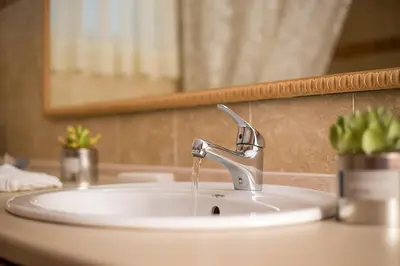 a bathroom sink with a faucet in front of a mirror at Villa Linda Tsambika Afandou in Afantou