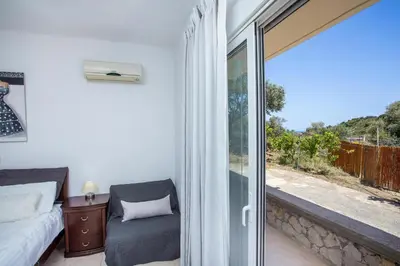a bedroom with a bed and a sliding glass door at Villa Linda Tsambika Afandou in Afantou