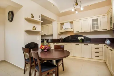 a kitchen with a wooden table and chairs at Villa Linda Tsambika Afandou in Afantou
