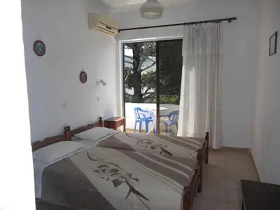 a bedroom with a bed and a view of a patio at Anthula Sun in Archangelos