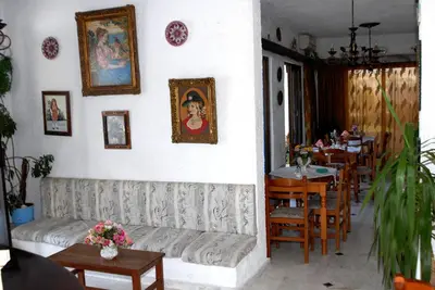 a restaurant with a couch and tables and chairs at Anthula Sun in Archangelos