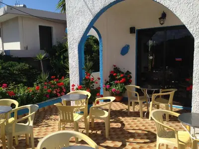 a patio with tables and chairs in front of a building at Anthula Sun in Archangelos