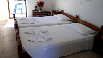 two beds with white sheets and towels on them at Anthula Sun in Archangelos