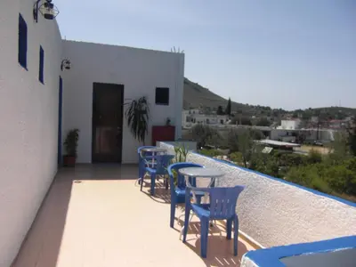 a patio with chairs and tables on a balcony at Anthula Sun in Archangelos