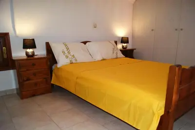 a bedroom with a bed with yellow sheets and two lamps at Pitini Nikos house in Symi