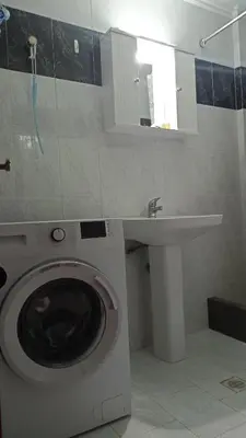 a bathroom with a washing machine and a sink at Pitini Nikos house in Symi