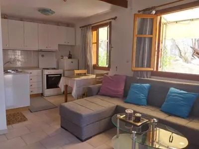 a living room with a couch and a kitchen at Pitini Nikos house in Symi