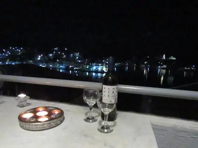 a table with a bottle of wine and two glasses at Pitini Nikos house in Symi