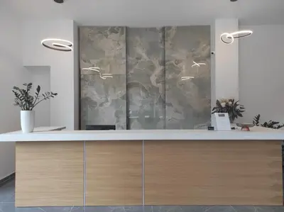 a reception desk in a office with a marble wall at Santa Maria City Hotel in Rhodes Town