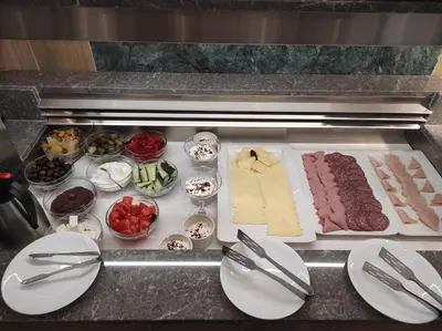 a counter with different types of meats and other foods at Santa Maria City Hotel in Rhodes Town