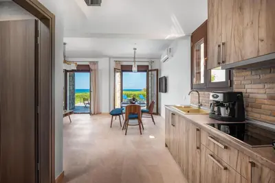 a kitchen with wooden cabinets and a table with chairs at Diagoras & Attalos Villas in Phanaes