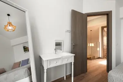 a bedroom with a white vanity and a mirror and a bed at Diagoras & Attalos Villas in Phanaes
