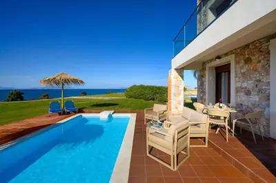 a villa with a swimming pool and a table and chairs at Diagoras & Attalos Villas in Phanaes
