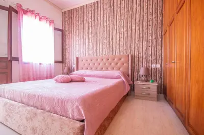 a bedroom with a pink bed with two pillows on it at Villa Elion in Symi