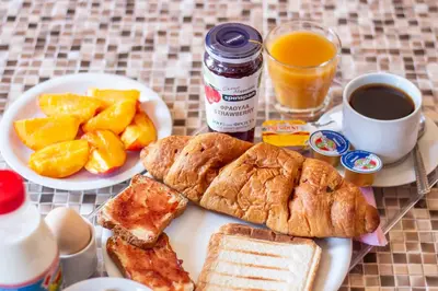 a table with a plate of food with bread and fruit at Villa Elion in Symi