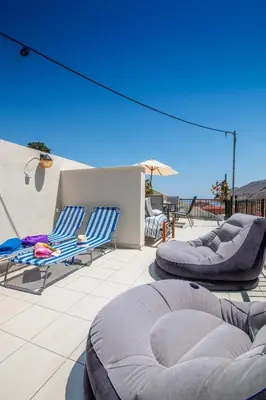 a patio with two chairs and a couple of tables at Villa Elion in Symi