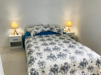 a bedroom with a blue and white bed with two lamps at Stegna Breeze in Archangelos