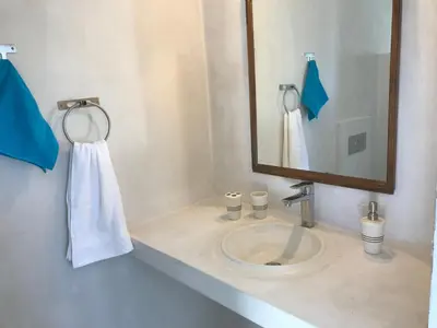 a bathroom with a sink with a mirror and a towel at Stegna Breeze in Archangelos