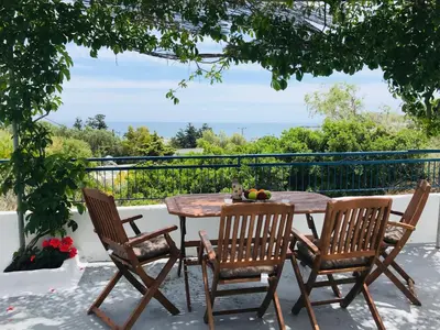 a table and chairs on a patio with a view at Stegna Breeze in Archangelos