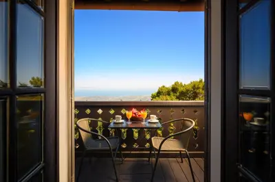 a table and chairs on a balcony with a view at Elafos Hotel in Sálakos
