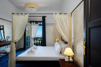 a bedroom with a bed with curtains and a window at Elafos Hotel in Sálakos