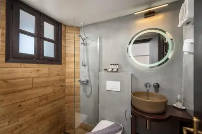 a bathroom with a sink and a shower with a mirror at Elafos Hotel in Sálakos