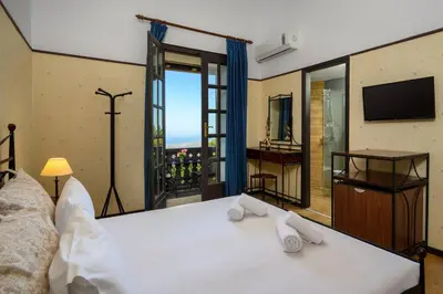 a bedroom with a bed and a large window at Elafos Hotel in Sálakos