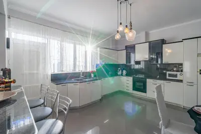 a kitchen with white cabinets and a table and chairs at Fontana Luxury Villa Salakos With Pool Near Beach in Sálakos