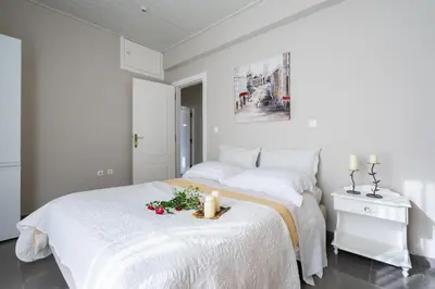 a white bedroom with a bed with two candles on it at Fontana Luxury Villa Salakos With Pool Near Beach in Sálakos