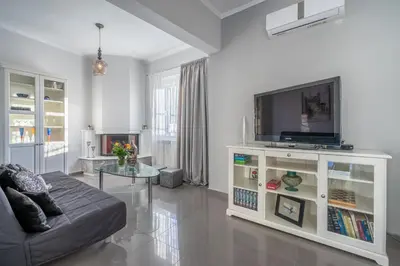 a living room with a couch and a flat screen tv at Fontana Luxury Villa Salakos With Pool Near Beach in Sálakos