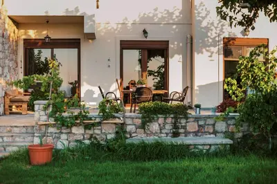 a house with a stone wall and a patio at Hillwings Villa in Faliraki