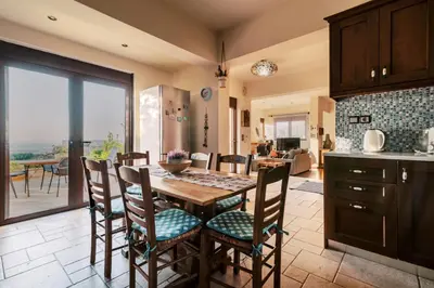 a kitchen and dining room with a table and chairs at Hillwings Villa in Faliraki