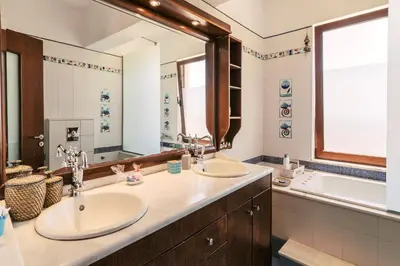 a bathroom with two sinks and a large mirror at Hillwings Villa in Faliraki