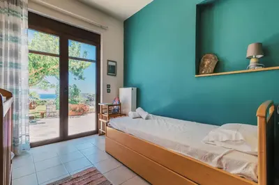 a bedroom with a bed and a sliding glass door at Hillwings Villa in Faliraki