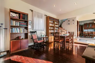 a living room with a table and chairs and bookshelves at Hillwings Villa in Faliraki