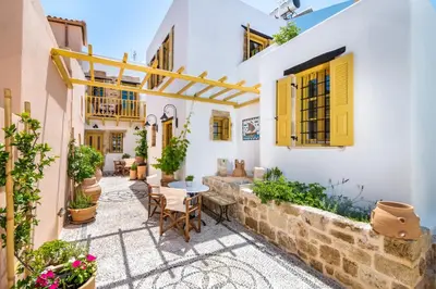 a courtyard in a house with a table and chairs at Villa il Vecchio Cortile in Rhodes Town