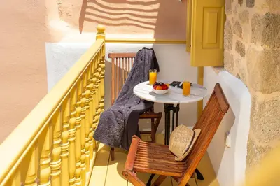 a small table and chairs on the balcony of a house at Villa il Vecchio Cortile in Rhodes Town