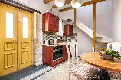 a kitchen with a wooden table and a yellow door at Villa il Vecchio Cortile in Rhodes Town